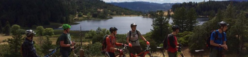 Mountain bikers taking a rest on Meander Trail overlooking the lake.