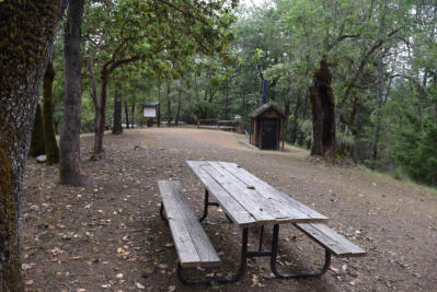 Off-season image of Sunrise Ridge campsite picnic table and KYBO.